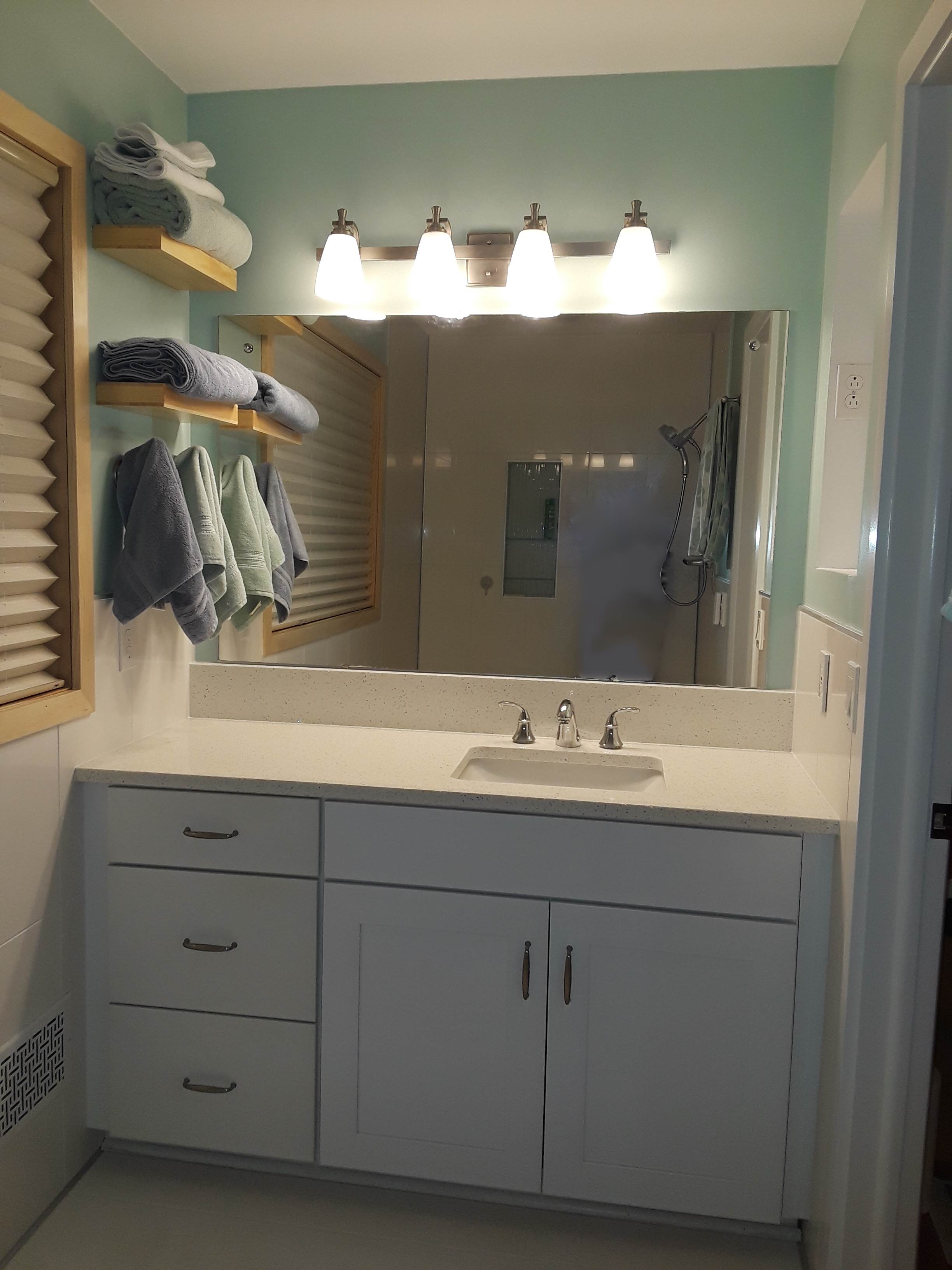 A white vanity with a mirror behind it.
